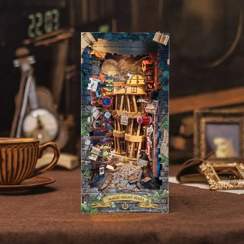 A completed model of a miniature world kit titled 'Magic Alley', featuring intricate details and a fantasy-themed setting, displayed on a table with a cup and frame in the background.